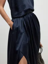 Falda midi azul marino de acetato, corte tubo, con frunces laterales, abertura diagonal y cintura elástica.