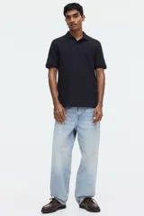 Remera polo de manga corta en piqué de algodón color negro, con cuello clásico y tapeta de dos botones. Corte estándar para una silueta clásica y cómoda.