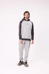 Canguro con capucha de estilo deportivo, con cuerpo en color celeste y mangas raglán en color negro. Presenta el logo de la marca estampado en el pecho, bolsillo tipo canguro frontal y franjas blancas laterales en las mangas.