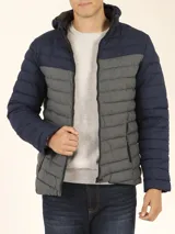 Campera capitoneada con capucha, con cambio de color tipo colorblock en verde militar y negro.