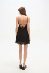 Vestido corto de poliéster con estampado de lunares, escote pronunciado en V y tirantes finos. El corte es ajustado en el busto y se abre ligeramente en la falda.