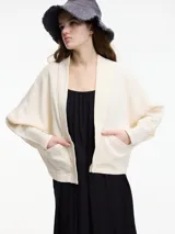 Cardigan de tejido de punto color crema, con cuello chal, mangas amplias y bolsillos delanteros.