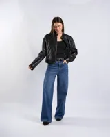 Campera de cuero sintético negro estilo motero con cuello mao, cierre frontal, bolsillos con cierre y detalles de tachas en hombros y mangas.