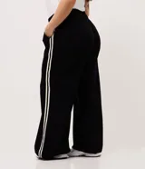 Pantalón pantalona negro de algodón, de corte amplio y cómodo con cintura elástica. Presenta franjas laterales a contratono de diseño deportivo.