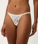 Kit de dos bombachas colaless tipo string confeccionadas en encaje floral, una en color negro y otra en color blanco. Presentan laterales finos regulables con tirantes elásticos y un pequeño dije metálico dorado en la parte frontal.