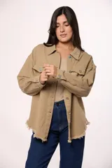 Sobrecamisa de jean color marrón, con cierre frontal de botones metálicos, bolsillos frontales con solapa y ruedo deshilachado.