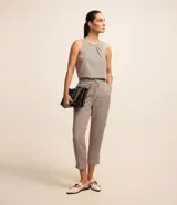 Pantalón fluido de corte recto y largo al tobillo, confeccionado en crepé con estampado geométrico en tonos beige y negro. Cuenta con cintura elástica ajustable con lazo del mismo tejido y bolsillos laterales.