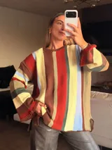 Sweater de tejido de punto con diseño de rayas verticales multicolores. Presenta cuello redondo, silueta oversize, mangas largas acampanadas y terminaciones en crochet.