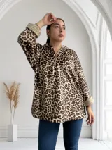 Buzo con capucha y cierre frontal, de animal print color marrón y beige, con puños de piel sintética color crema.