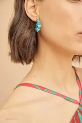 Caravanas tipo aro con incrustaciones de piedras turquesas irregulares.