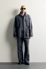Parka relaxed fit de algodón color gris con efecto lavado. Cuenta con cuello solapa, cuatro bolsillos de plastrón con solapa en el frente y cierre frontal con cremallera oculta por solapa con botones a presión.