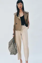 Bolso tipo shopper de tejido con diseño de cuadros en tonos verdes, blancos y marrones, decorado con apliques brillantes. Cuenta con asa de hombro ajustable en material sintético negro, cierre mediante botón imantado y bolsillo interior con cremallera.