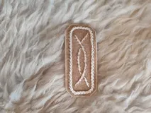 Broche para pelo artesanal de cuero con bordados en tiento fino.