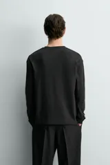Camiseta relaxed fit de manga larga y cuello redondo, confeccionada en tejido de mezcla de algodón y lino, en color negro.