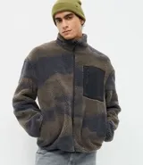 Campera de sherpa con estampa camuflada y cierre frontal, de manga larga, corte oversize, cuello alto y bolsillo negro contrastante en el pecho.