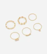Kit de seis anillos de metal en tono dorado con diseños variados, incluyendo modelos lisos, con textura, con apliques de hojas y detalles de zirconia.