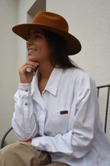 Sombrero marrón de ala ancha confeccionado en paño de lana afieltrada a mano, con cinta decorativa del mismo material alrededor de la copa.