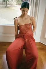 Musculosa de georgette en color bordó, con escote recto, tirantes finos y detalle de aplicación de encaje floral en la parte superior.