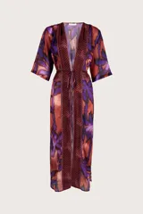 Cover up largo tipo túnica con escote en V, mangas tres cuartos y lazo ajustable en la cintura. Presenta un estampado vibrante de hojas en tonos púrpuras y cobrizos con detalles geométricos en los bordes frontales.
