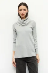 Polera color beige de cuello alto extendible, manga larga y pequeñas aberturas en los laterales.