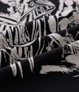 Remera negra de algodón con estampado localizado de la banda Aerosmith en tonos naranja y amarillo. Presenta cuello redondo y manga corta.