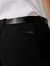 Pantalón negro de crepé elástico, corte recto, cintura plisada, bragueta con cremallera y bolsillos con ranura.