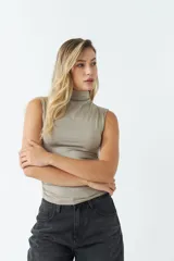 Top sin mangas de cuello alto, confeccionado en tejido liviano y suave con ajuste al cuerpo.