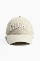Gorra de sarga color beige con efecto lavado, visera curva y diseño bordado en relieve con la inscripción "CHICAGO ILLINOIS" en el frente.