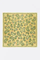 Pañuelo cuadrado de poliéster color amarillo con estampado paisley en tonos verdes, naranjas y celestes, con bordes decorados.