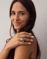 Anillo dorado con forma irregular y un agujero en el centro.