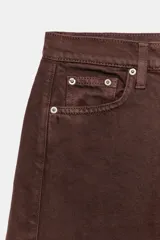 Bermuda de denim color bordó, de tiro medio y corte relaxed, con diseño de cinco bolsillos, trabillas para cinto y bajo desflecado.