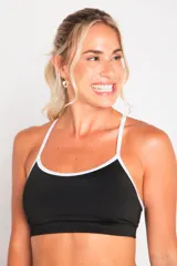 Top deportivo negro de lycra suplex con breteles regulables y contorno blanco.