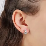 Aros plateados con forma de flor con un cristal en forma de gota en la parte superior y tres cristales redondos en la parte inferior.