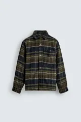 Sobrecamisa de corte relajado confeccionada en tejido con textura efecto pelo. Presenta diseño de cuadros en tonos verde y negro, cuello solapa, cierre frontal con botones, manga larga con puños abotonados y un bolsillo de plastrón en el pecho.