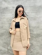 Camisa color beige de manga larga con botones y bolsillo en el pecho.