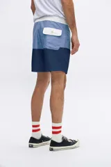 Shorts de baño con diseño color block en celeste y azul marino, con cintura elástica y cordón ajustable.