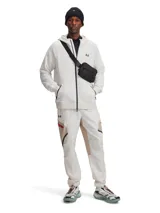 Pantalón cargo técnico de Under Armour, confeccionado en tejido elástico con tecnología UA Storm repelente al agua. Presenta un diseño en tonos beige y blanco con paneles en contraste, bolsillos laterales con cremallera, cintura elástica con cordón interno y bajos ajustables con cordón elástico.