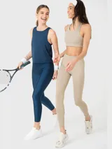 Musculosa deportiva de entrenamiento color azul denim, con cuello redondo y diseño de costuras laterales. Confeccionada en tela suave y fresca, cuenta con panel de malla en la espalda para mayor ventilación.