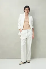 Top blanco tejido con tiras para anudar en los hombros y diseño tramado.