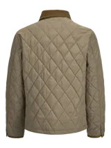 Campera acolchada de diseño matelasse en color tostado, con cuello camisero en pana marrón, cierre frontal con broches a presión, bolsillos frontales con solapa y puños ajustables.