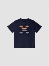 Remera blanca de algodón orgánico con cuello redondo y manga corta. Presenta un estampado en el pecho con una cruz formada por dos tablas de surf en tonos rojo, azul y negro.