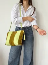 Cartera tipo sobre de cuero con diseño de rayas verticales en tonos verde menta y marrón tostado. Cuenta con detalles de borlas colgantes en los laterales.