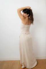 Conjunto de dos piezas compuesto por un top strapless con frunces laterales y una pollera-pantalón cruzada con abertura frontal. El diseño incluye short interno y bolsillos laterales, confeccionado en un textil liviano.