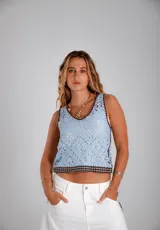 Blusa sin mangas tejida en crochet, color celeste con detalles de bordes en color marrón oscuro. Presenta un diseño de motivos florales geométricos y escote en V.