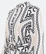 Vestido midi estilo chemise de satén con estampado de cadenas en blanco y negro. Tiene cuello redondo, mangas largas con puños elásticos, abotonadura frontal y cinturón con hebilla redonda.
