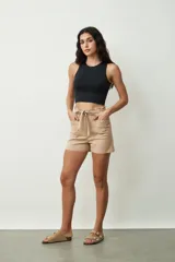 Short de tiro alto con estampado botánico en tonos verdes y crudos. Presenta una cintura elástica con lazo ajustable del mismo tejido, bolsillos laterales y un corte holgado.