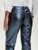 Pantalón de tiro alto, corte recto y ligeramente acampanado en la parte inferior, color azul oscuro metálico con acabado brillante. Presenta costuras visibles en el frente de las piernas y aberturas en los tobillos.