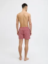 Short de baño Jack & Jones con diseño de rayas verticales rojas y blancas, estampado con pequeños veleros oscuros. Cuenta con cintura elástica con cordón ajustable, bolsillos laterales y un bolsillo trasero.