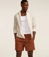 Bermuda de baño color beige, confeccionada en tejido ana ruga texturizado. Tiene lazo en la cintura, bolsillos laterales y un bolsillo trasero.