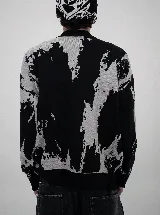Buzo de punto con diseño abstracto en blanco y negro, con estampado gráfico estilo gótico en el pecho y detalles de roturas desgastadas en el tejido.
